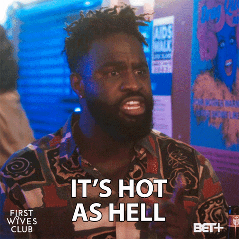 TV gif. Terrence Terrell as Wesley from First Wives Club. He's sitting in a dark bar and a sheen of sweat is on his forehead as he informs his friend, "It's hot as hell."