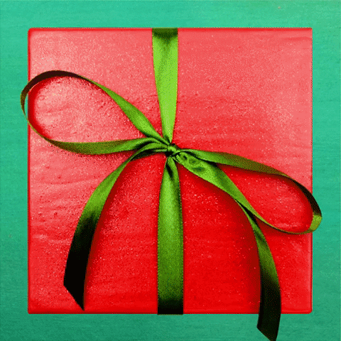 Stop motion gif. Green ribbon bow unties itself from a red square box, and after the lid lifts off, a piney wreath spirals out from the center, with a gold heart rotating outward. Yellow text appears against a teal background, "Merry Christmas."