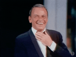 Celebrity gif. Frank Sinatra laughs and holds a hand to his chest at the Academy Awards in 1969.