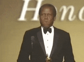 Celebrity gif. Sidney Pointer is accepting an award at the Oscars and he exhales heavily on stage while looking around. He puts a hand to his chest and he clutches himself, taking in the moment.