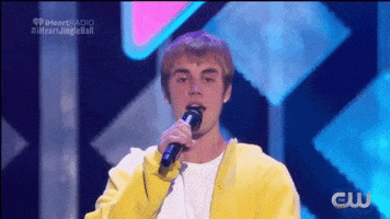 Celebrity gif. Justin Bieber performs onstage, looks at us while saying something into the mic, then points at us.