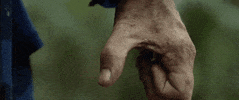 Video gif. A dirty man's hand slowly curls into a fist. 