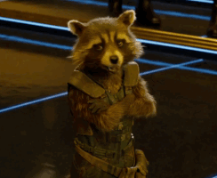 Movie gif. Rocket from Guardians of the Galaxy shows his fangs as he gives us an exaggerated wink.