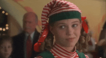 Movie gif. Jennifer Morrison as Denise in "Miracle on 34th Street," wearing a striped elf hat and turtleneck, rolls her eyes.