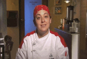 Reality TV gif. A female chef on Hell’s Kitchen sits and smiles at us. A poorly done lighting effect strikes her and she poofs off screen, leaving behind a single flame in her place.