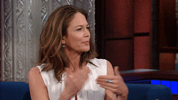Late Show gif. Diane Lane is on the show and she squints at Stephen before moving her hands around confusedly. She puts a hand to her chin and looks up at the ceiling, contemplating.