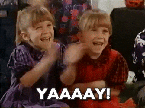 two little girls are sitting next to each other laughing and clapping .