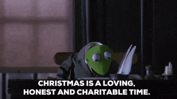 Cartoon gif. Kermit from The Muppet Christmas Carol. He sits at a desk in a suit and looks up while giving us a gentle smile and says, "Christmas is a loving, honest, and charitable time."
