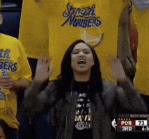 Sports gif. Ayesha Curry stands in a crowd of Warriors fans and claps as she cheers, saying, "Let's go!"