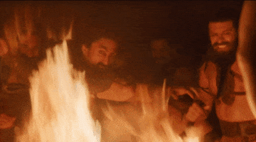 TV gif. Emilia Clarke as Daenerys in Game of Thrones. She's staring down a group of men who are crying and rolling on the ground behind a huge bonfire.