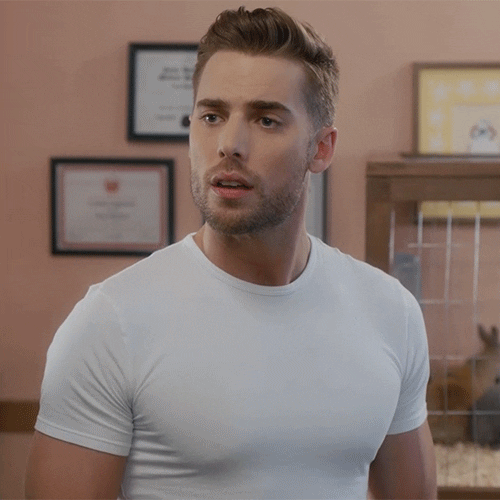 TV gif. Dustin Milligan as Ted in Schitts Creek stands in an office wearing a snug white T-shirt. He looks away and then back towards us like he's still lost on the conversation. Text, "Oh."