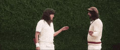 Music video gif. In the video for Avant Gardener, dressed like preppy tennis players, Courtney Barnett and a man slap hands and then point finger guns at each other.
