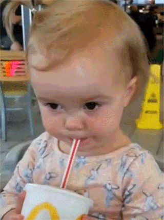 Video gif. A baby sips out of a straw and closes her eyes as she puckers her lips. She leans back from the cup with a frown as one eye twitches and she drops her head back behind her.