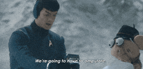 Ad gif. Standing in a snowy area, Ethan Peck as Spock in a Paramount Plus ad tends to a Crank Yankers puppet that is shivering with a block of ice for an arm. Spock looks over his shoulder as he holds a device over the ice block arm, and shouts, “We’re going to have to amputate.”