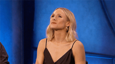 Celebrity gif. Kristen Bell blowing rapid-fire kisses on stage towards an audience at Conan Con 2019.