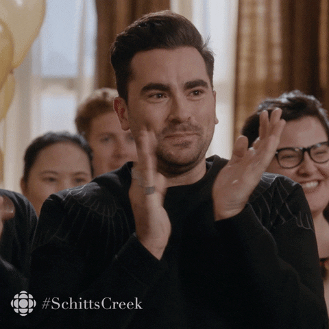 Schitt's Creek gif. Dan Levy as David claps his hands and pumps his fists as he smiles with emotion in his eyes.