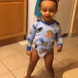 Video gif. A toddler in a diaper dances by shaking his legs and twirling his arms