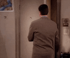 Friends gif. David Schwimmer as Ross opens the door to his apartment and turns around with a smug look on his face. He says, “cool,” quickly and then leaves his apartment with a smile on his face. 