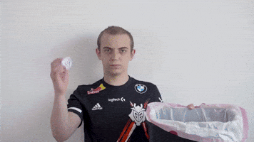Video gif. Caps the Danish gamer stands unimpressed as he tosses a crumpled up piece of paper in a trash bin. 