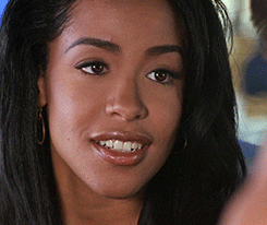 Movie gif. Aaliyah as Trish in Romeo Must Die gives a flirtatious wink. 
