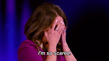 Reality TV gif. A female judge on I Can See Your Voice covers her face in fear as she says, “I'm so scared.”