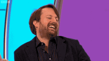TV gif. David Mitchell in Would I Lie to You? waves his hand playfully then points at someone.
