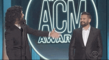 Celebrity gif. Dan and Shay onstage at American Country Music Awards show gesturing with their arms at each other and saying, "I love you, man!" which appears as text.