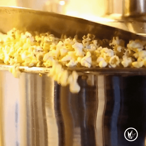 Video gif. A pot full of popcorn sills over as the popcorn pops inside of it.