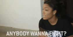 Reality TV gif. Mehgan James on Bad Girls Club looks at someone with a serious expression and points around with her hand as she says, “Anybody wanna fight?”