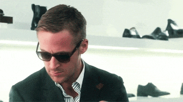 Movie gif. Ryan Gosling as Jacob in Crazy Stupid Love wears sunglasses as he looks down in confusion before backing away and looking up.