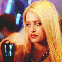 Video gif. A blonde woman with a cold, calculating stare sips a drink through a straw without changing her expression.