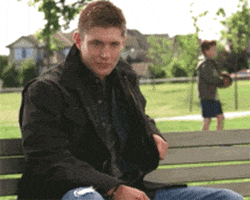 TV gif. Jensen Ackles as Dean in Supernatural sits on a park bench and gives a hearty thumbs up.