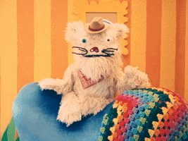 TV gif. Scruffy, a fluffy puppet dog wearing a cowboy hat, in "Happy Place" sits on the back of a blue chair, flapping his mouth open and closed in a bright living space decorated with cartoonish decor. Text, "A good night."