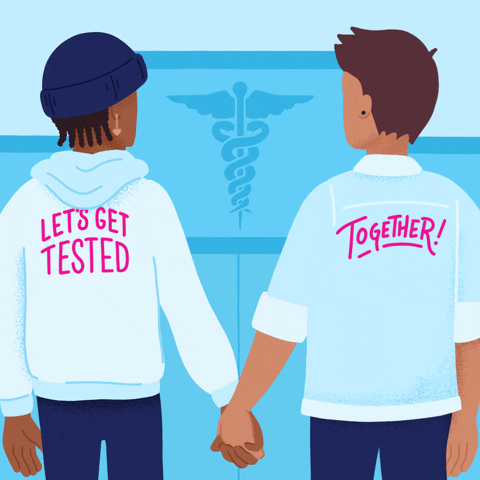 Digital art gif. Illustration of two people of ambiguous genders holding hands and looking at each other while standing outside a doctor's office. On the backs of the people's shirts, text reads, "Let's get tested together."