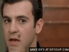 Austin Powers comically showing off a large, phallic object (likely a prop or representation of his 'mojo') with a proud expression