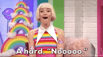 SNL gif. Chloe Fineman wears a blonde blunt bob, a rainbow shirt, and many stickers over her arms like she’s a life size polly pocket doll. She tilts her head and shakes it with a very fake wide smile as she says, “A hard, noooo.”
