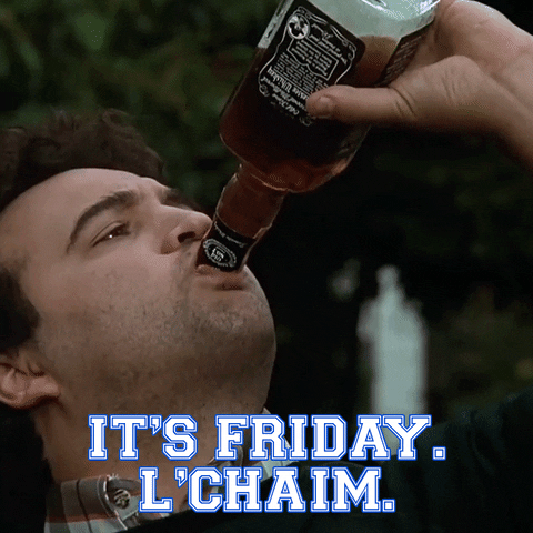 Movie gif. John Belushi as Bluto in Animal House infinitely chugs a handle of Jack Daniels bourbon. Text, "It's Friday, l'Chaim."