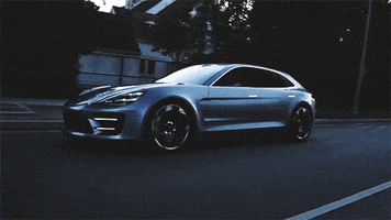 Video gif. A brand new silver Porsche Panamera Sport Turismo drives smoothly down the road, gleaming.