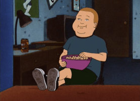 Cartoon gif. Bobby Hill on King of the Hill has his feet up on his bed and leans back in a chair as he happily munches on a bowl of popcorn.