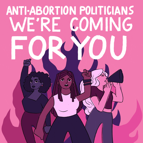 Digital art gif. Illustration of three angry women, two with their fists raised and one shouting into a megaphone, standing in front of purple and pink flames. White text above the women reads, "Anti-abortion politicians, we're coming for you," all against a pink background.