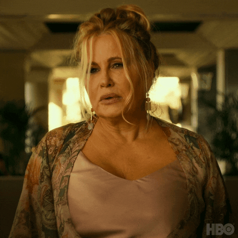 TV gif. Jennifer Coolidge as Tanya in The White Lotus appears sad as she asks, "Could I get some alcohol?"