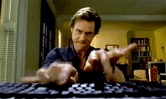 Movie gif. Jim Carrey as Bruce in Bruce Almighty furrows his brow and bites his lip as he pounds wildly on a computer keyboard in the foreground.