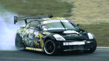 Sports gif. Nissan 350z Tokyo drifts, wheels smoking, and recovers.