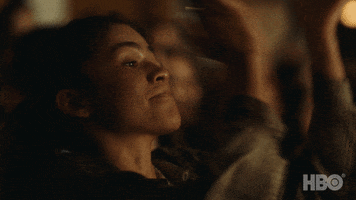 TV gif. Zendaya as Rue on Euphoria sits in an audience of people and claps along with everyone. Rue looks over her shoulder and smiles. 