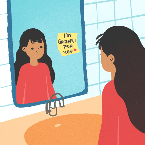 Illustrated gif. Girl stands over a sink and looks at her reflection in the mirror, blinking and smiling slightly. A yellow note with a red heart is taped to the mirror and reads, "I'm grateful for you."