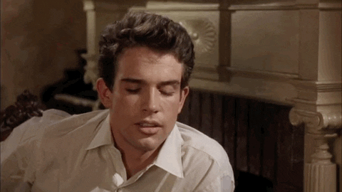 Movie gif. Warren Beatty as Bud Stamper in Splendor in the Grass sits down next to a fireplace. He looks down, blinking fast as if hearing something shocking, and raises his eyebrows as if responding to what he just heard without words.