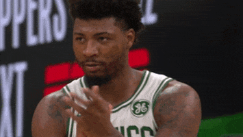 Sports gif. Marcus Smart of the Celtics claps his hands as he walks forward and glances around.