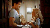 TV gif. Mark Deklin as Blake on GCB holds a stack of books and looks quizzically at Kristin Chenoweth as Carlene, who points at him cutely and smiles as she says, "praying for you," which appears as text.