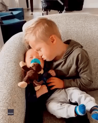 Little Boy With Down Syndrome Comforts Baby