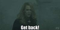TV gif. Sarah Paulson as Cordelia on American Horror Story breathes deep and reaches her hand forward, shouting, "get back!" which appears as text.